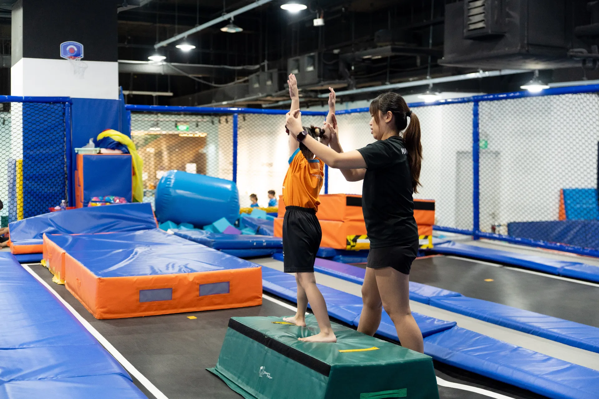 A Coach teaching gymnastics to kids.