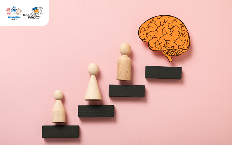 wooden figurines depicting a brain with a person standing on top