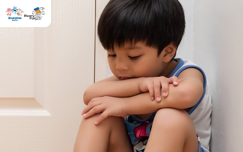 Shy kid sitting in the corner of a room