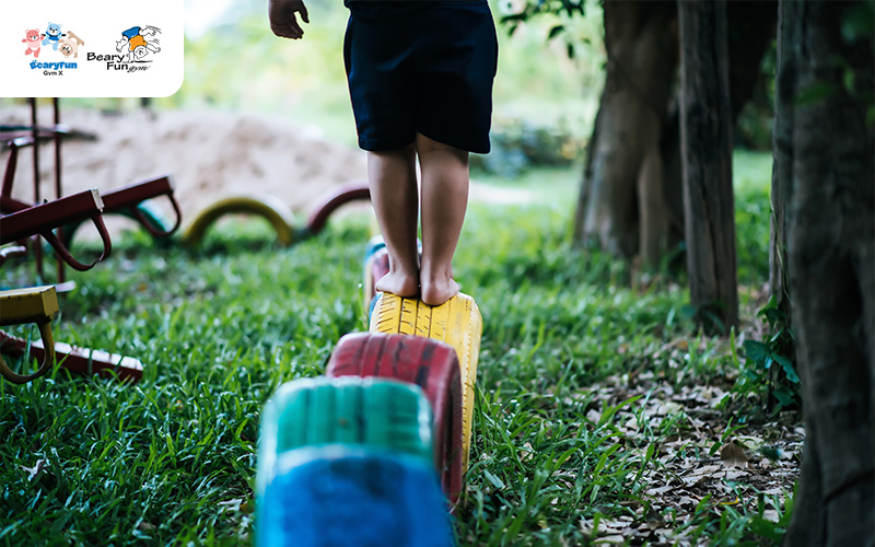 Child balancing on low playground tires.