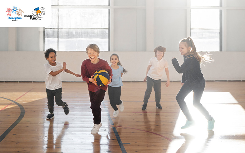 Children playing during gymnastics class warm-up.