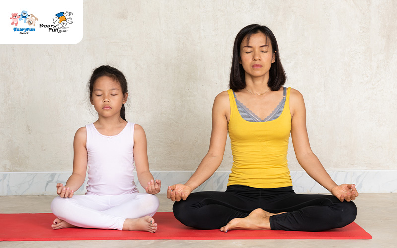 Parent and child meditating before gymnastics class.