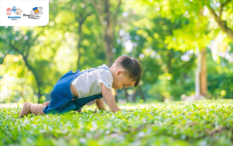 Toddler tripping on grass, showing signs of poor coordination.