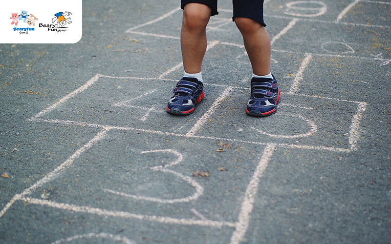 Child's feet on a hopscotch court.