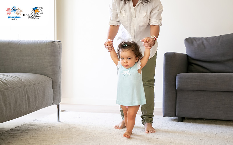 Baby learning to walk, a physical development milestone.
