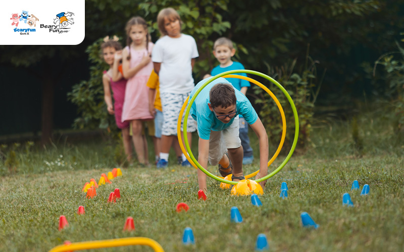 Child crawling through a hoop in an obstacle course.