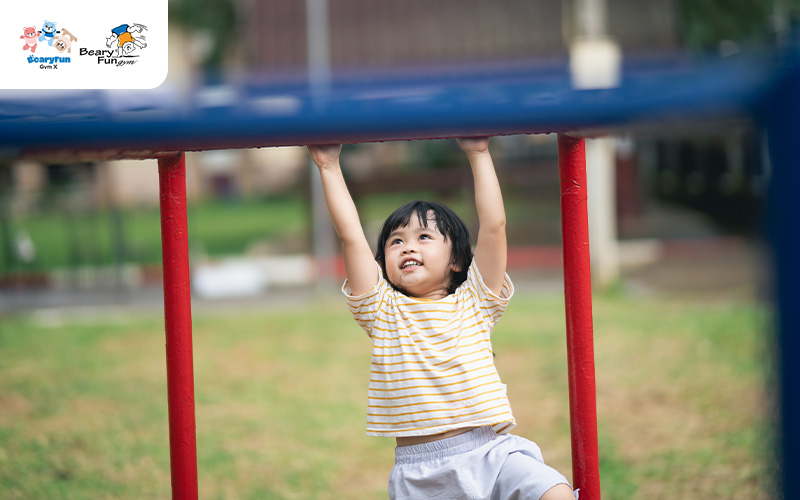 Child playing on monkey bars at a playground.