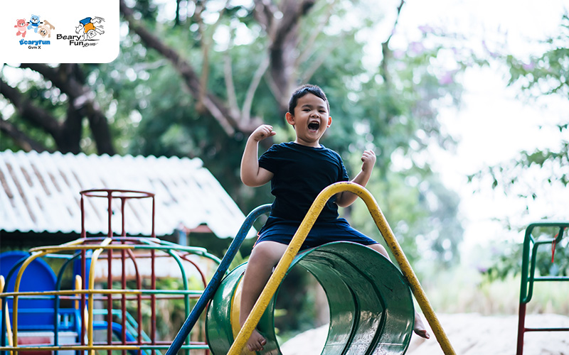 Child playing on a colorful playground structure, having fun.