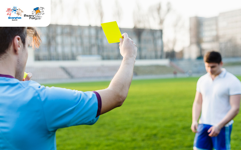Referee showing a yellow card during a soccer game.