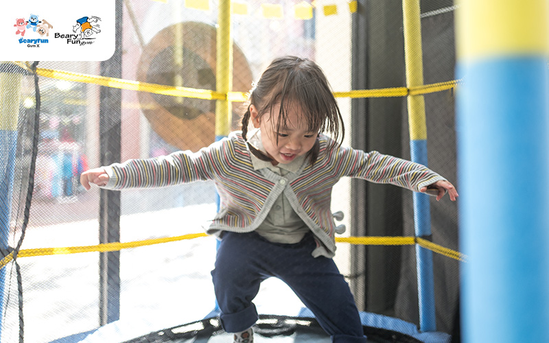 Young child jumping on a trampoline.